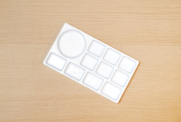 White watercolor palette. Empty watercolor tray isolated on wood background. White paint palette.