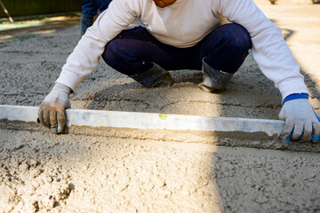 Worker is leveling fresh concrete after pouring