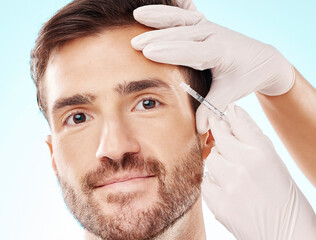 Portrait, man and needle for cosmetics, dermatology and beauty on blue studio background. Face,...