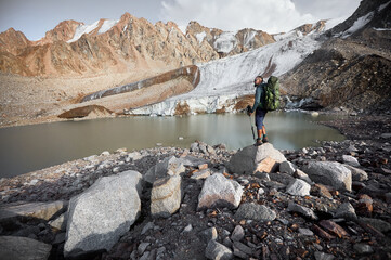 Fototapeta na wymiar Hiker tourist with backpack at mountain lake