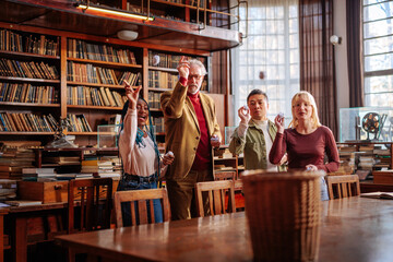 Professor and students playing in library.