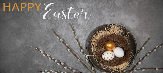 HAPPY EASTER holiday celebration backgroud greeting card with text - Easter nests with gold painted easter eggs and catkins on concrete table texture, top view