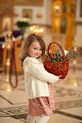 Palm Sunday. Cute smiling girl in the temple with a sprigs of willow