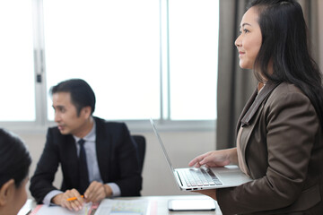 Collaborative process of professional businesspeople going over on new project together, using computer presentation and brainstorming ideas, coworker and working together at office meeting concept
