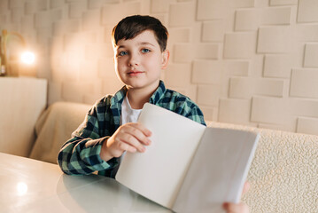 Kid school boy doing homework at home. Remote education. Reading writing subjects