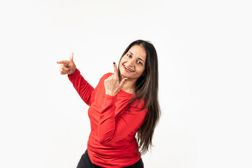 Happy attractive indian woman dancing and having fun, raising hands up carefree, enjoying music