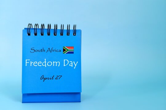 April 27 as South Africa Freedom Day date reminder on blue desk calendar with flag icon. National day celebration concept.