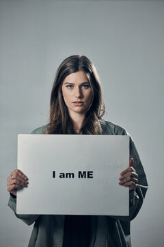 Woman, protest and poster in pride for self esteem, equality or human rights against gray studio background. Portrait of confident female activist with I am me message on board for unique empowerment
