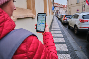 Woman, hand looks at map on phone and plots a route for a trip GPS navigator