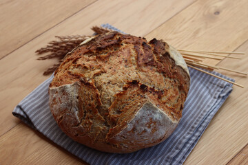 Wholegrain bread with spelt flour with linen and sunflower seeds on wooden table