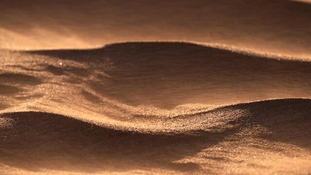 Sand blowing over dunes in wind, sandstorm in Gobi desert, close up