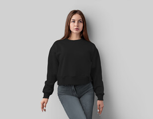 Mockup of black sweatshirt on pretty girl in jeans, casual apparel isolated on white background,...