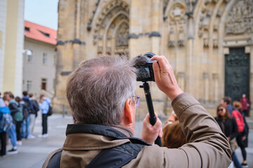 elderly aged Man photographer, tourist makes photo with mirror less camera