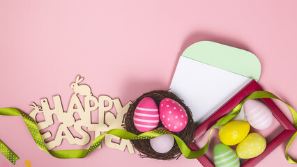 congratulatory post card with easter eggs and with blank white note on the pink background and place for text top view