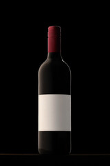 Wine bottle on black background with white label and red cap