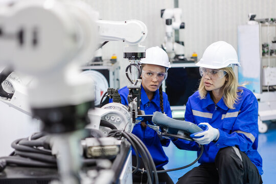 Team technician engineer using remote control automation robotics at industrial modern factory. woman working at factory innovation automation robot.