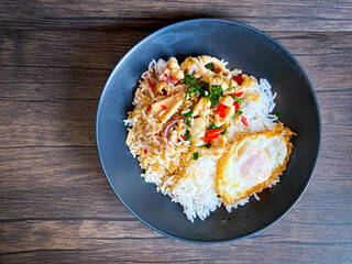 Rice topped with stir-fried squid and basil with fried egg