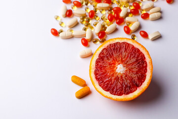 Vitamins, pills on a white background and citrus fruits - oranges