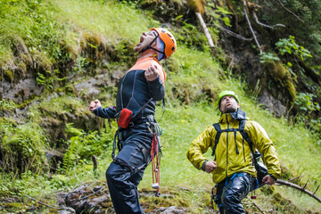 Two men show some emotion and humour during a canyoning trip