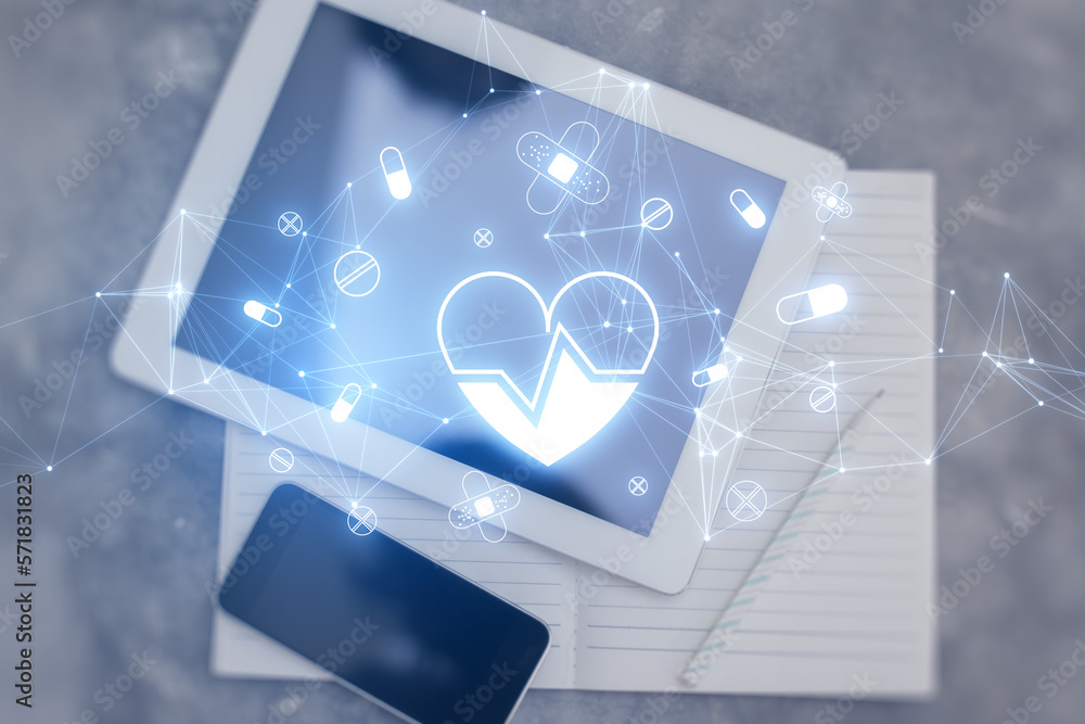 Poster Top view of desktop with tablet, notepad and cellphone with glowing heart hologram on blurry background. Cardiology and doctor's office concept. Double exposure.