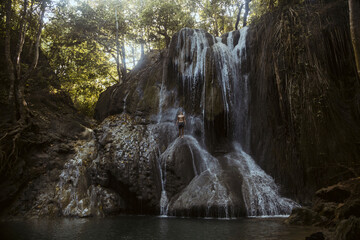 Young man is climbing on waterfall