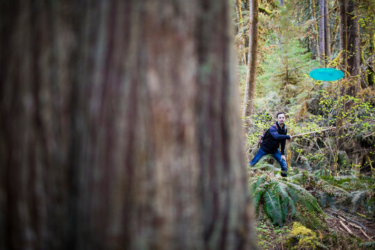 Man throws frisbee disk during a game of disk golf