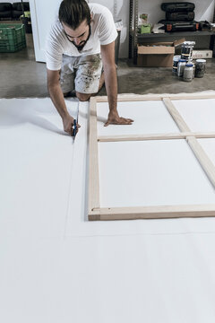 young painter works preparing the woods and the canvas to paint the fi