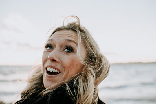 portrait of happy woman by the ocean - Powered by Adobe