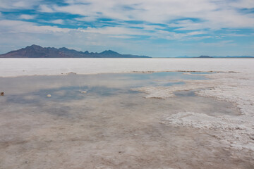 Scenic view of Bonneville Salt Flats near Wendover, Western Utah, USA, America. Densely packed salt pans and natural landscape near Salt Lake City. Water reflection of Silver Island Mountains peaks