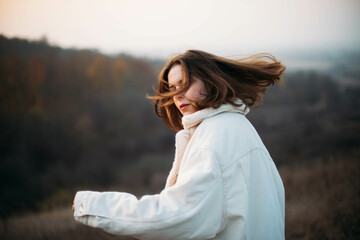 Portrait of a beautiful young woman in warm clothes during sunset