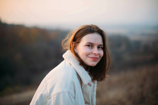 Portrait of a beautiful young woman in warm clothes during sunset