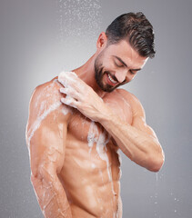 Shower, sponge and man with water in studio on gray background for wellness, grooming and beauty....