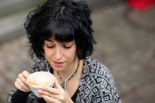 Young Woman With Laptop Outside Drinking Coffee