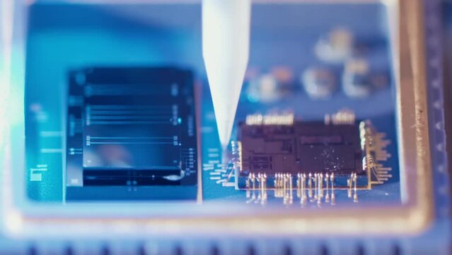Macro shot of wire bonder connecting wires to a microchip at high speed