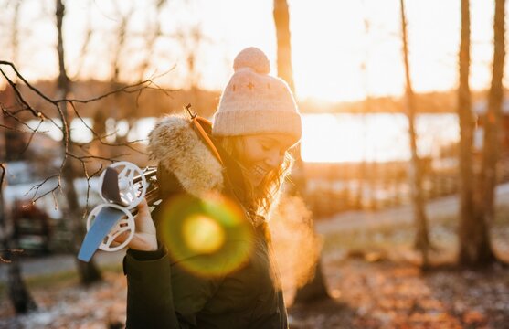 Portrait of a woman smiling holding skis at sunset