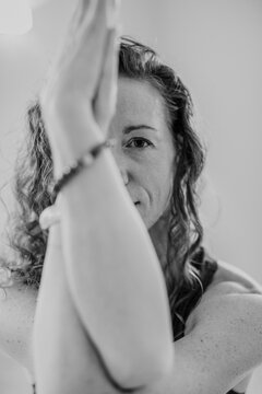 black and white image of woman's face while practicing yoga in a studi
