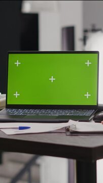 Vertical video: Team of coworkers looking at green screen template on laptop, working with isolated mockup display for business collaboration or partnership. People sitting in coworking office with