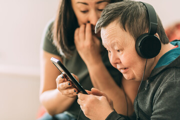 elderly woman with Down syndrome, assistant help her to use phone