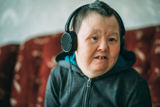 elderly woman with down syndrome wearing headphones, music
