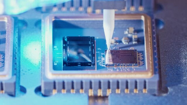 Macro shot of wire bonder connecting wires to a microchip at high speed