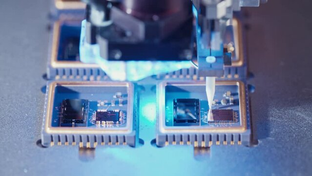 Macro shot of wire bonder connecting wires to a microchip at high speed