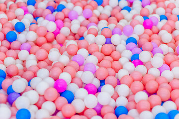 Background, close-up texture of many colored, multi-colored round plastic small balls on the playground for children's games. Photo, top view, copy space.