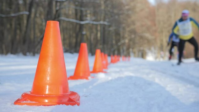 Skiers during the competition pass near the cones of the track fence. Video background for infographics on the topic of skiing or competitions. High quality 4k footage