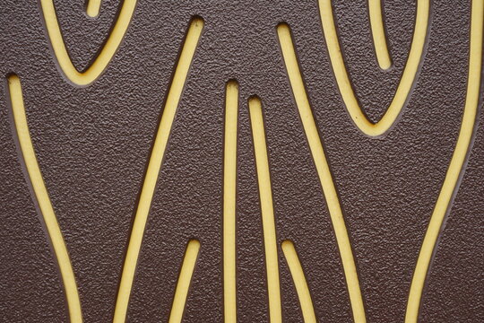 yellow indented lines on a brown jagged background