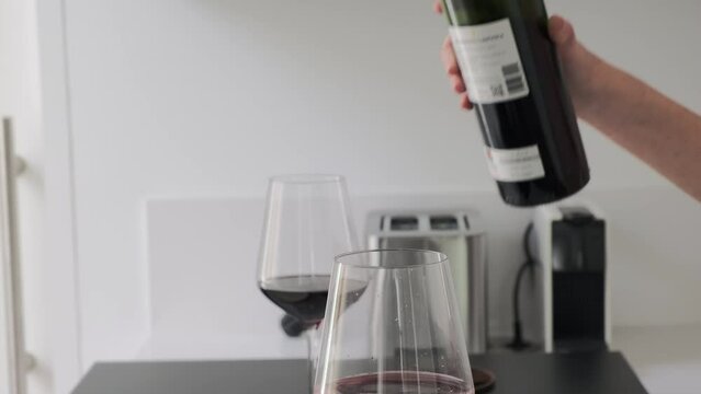 Una botella de vino tinto servido con estilo en una cocina minimalista y luminosa
