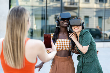 Young multiracial girls using futuristic virtual reality headset, having fun outdoors with technology and augmented reality online