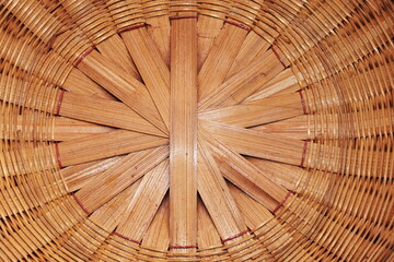 Weaved bamboo background. Closeup of woven bamboo surface painted light red by hand making household utensils in rural Thailand with selective focus.