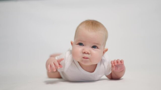 Portrait of a contented baby on a white background, concept stages of becoming a human being in a newborn state