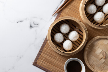 Fototapeta na wymiar Dumplings in bamboo steamer on marble background. Top view. Copy space