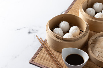 Fototapeta na wymiar Dumplings in bamboo steamer on marble background. Copy space